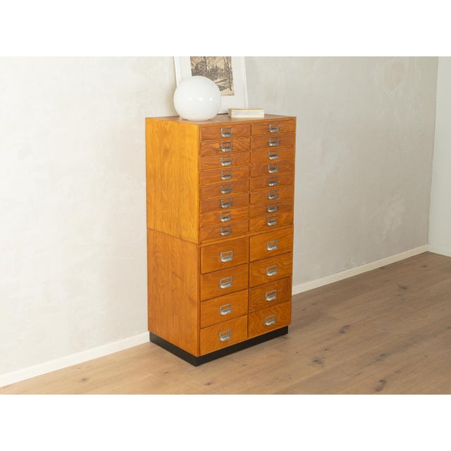 Unique two-part chest of drawers from the 1950s. High-quality body made of beech veneered particleboard with 16 small and...