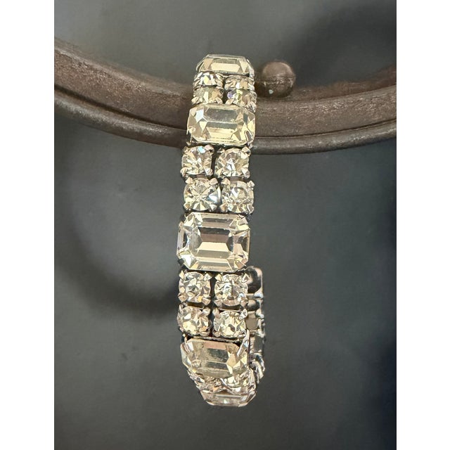 This stunning Art Deco-style bracelet features a classic geometric aesthetic, characterized by its symmetrical arrangement...