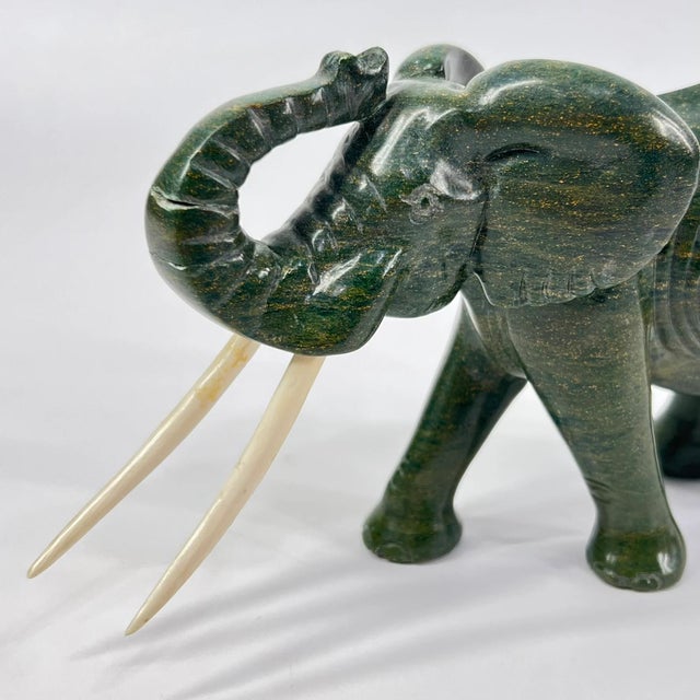 This hand-carved verdite elephant is a striking example of Shona sculpture from Zimbabwe. Crafted from richly colored...