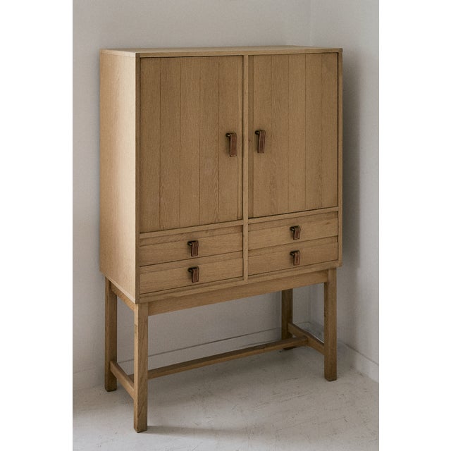 Light oak bar cabinet by Kurt Ostervig, 1960. This Danish wooden cabinet produced by K.P Mobler has two (2) doors that...