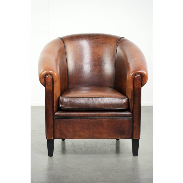 Beautiful and characterful sheepskin club armchair with lovely deep warm colors, black piping, and a comfortable seat. :...