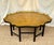 A Kittinger octagonal gold leaf coffee table on an ebonized faux bamboo base. Manufactured by the Kittinger Furniture...