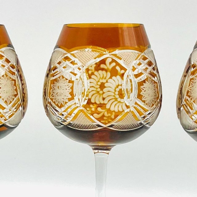 A unique set of amber cut-to-clear wine glasses, crafted in the rich Bohemian glassmaking tradition. These elegant stemmed...