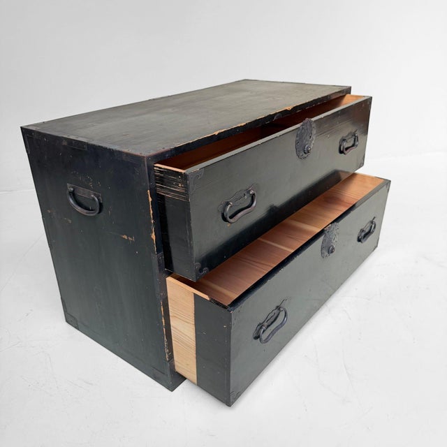This antique Japanese chest has a strong, understated silhouette with two spacious drawers and a deep dark-lacquered...