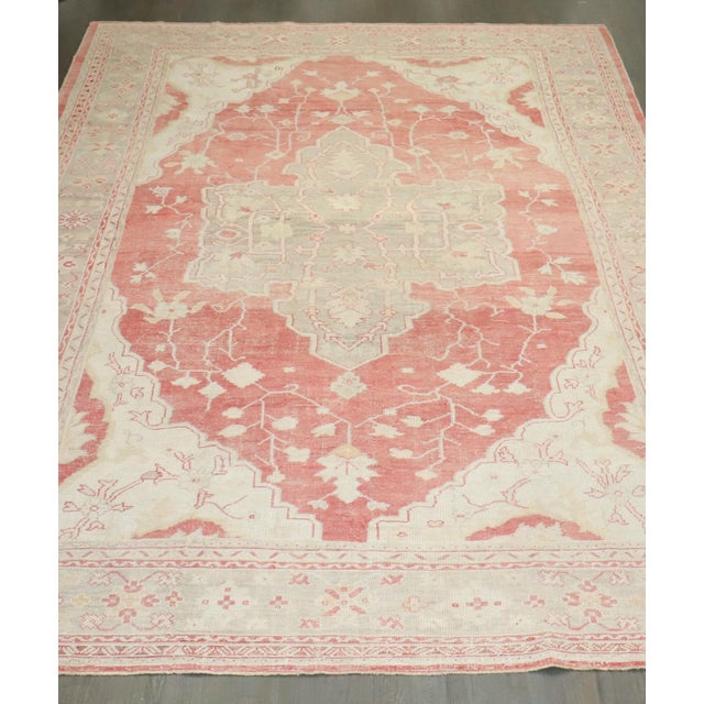 An early 20th century antique turkish oushak carpet in soft reds and creams