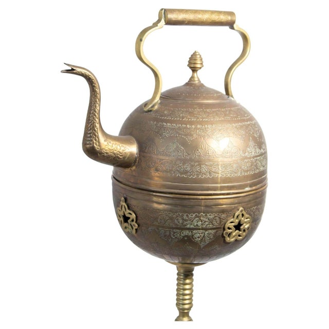 An extraordinary antique Moroccan hand-crafted brass tea kettle or water vessel presented on its original tall warming...