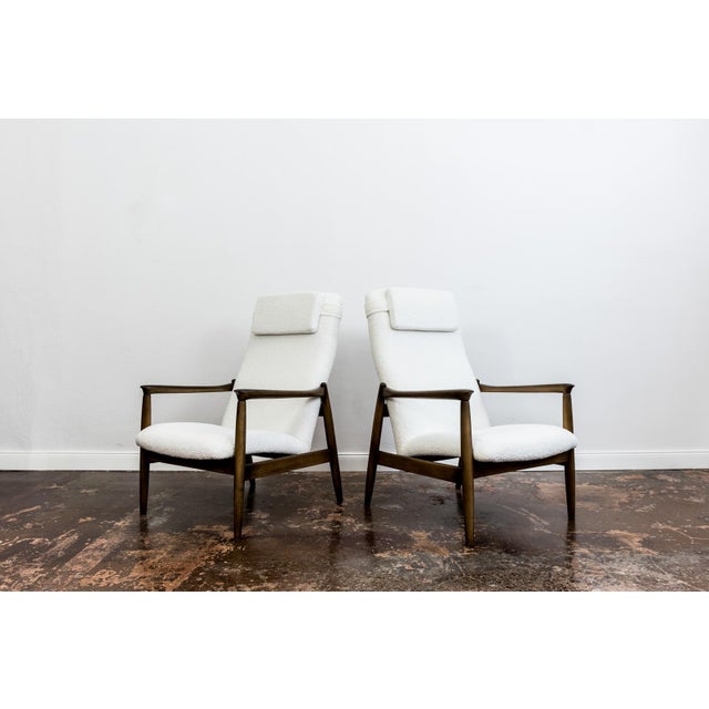 A pair of GFM-64 armchairs in a high-back version, designed by Edmund Homa, manufactured at the Gościcińska Furniture...