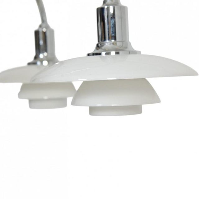 Poul henningsen ph2/1 bombardement chandelier with five arms and white opal glass shades, and a chrome frame. The lamp is...