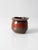 Vintage handmade studio pottery vessel featuring a rounded form, softly flared rim, and a rich red and charcoal glaze. The...