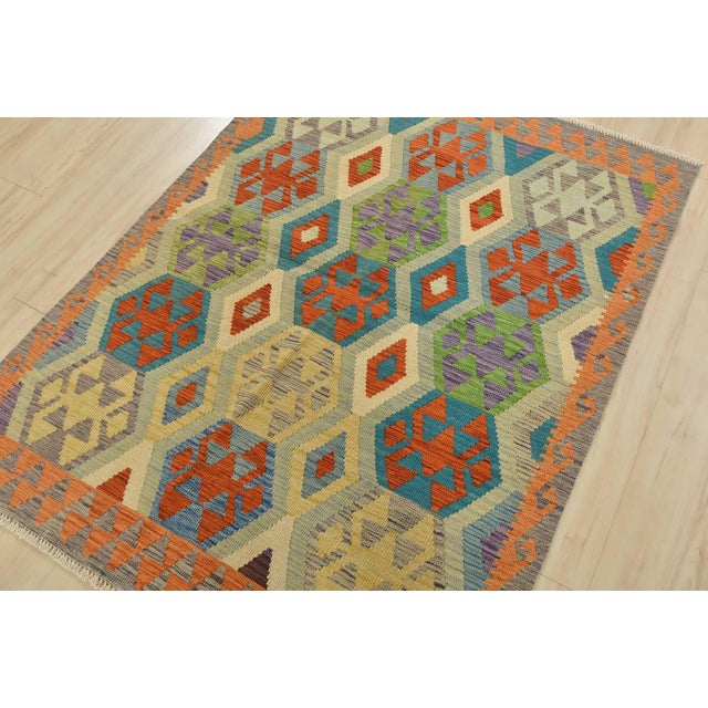 This tribal geometric Kilim rug is handwoven with all wool on a wool foundation. This rug is new and in excellent...
