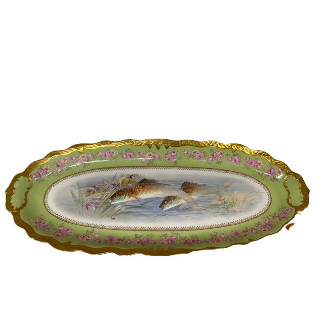 The Limoges porcelain fish oval serving platter features an aquatic scene of swimming fish, a light green and pink rose...