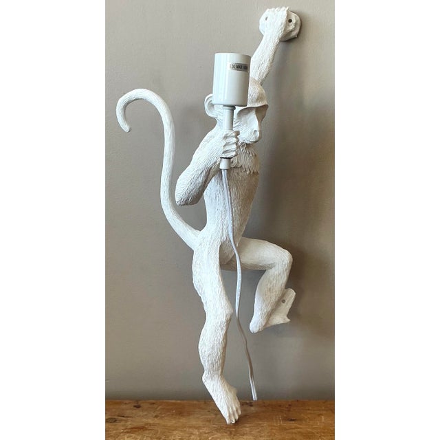 Inject a dose of playful charm and personality into your space with this delightful figural monkey wall sconce. Crafted...