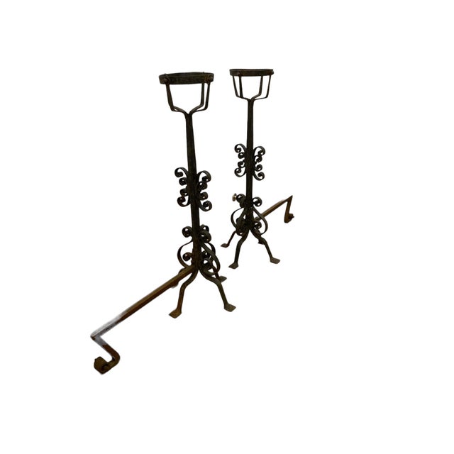 A pair of large french wrought iron fire dogs with large fire baskets. Impressive looking with a gothic style from mid to...
