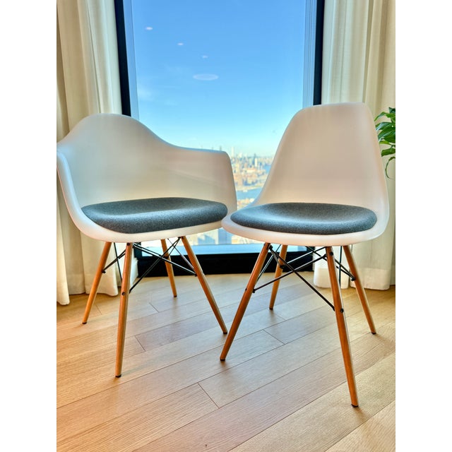 A Herman Miller/Eames original and design classic! Molded white dining side chairs with affixed grey-blue upholstered seat...