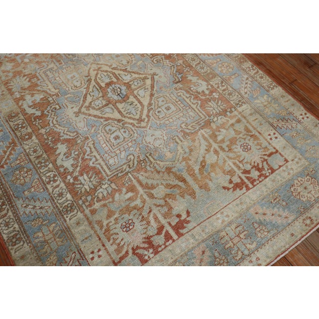 An accent size 20th century Persian Heriz rug in apricot rust and soft blue tones Measures: 4'6" x 6'3" Heriz antique...