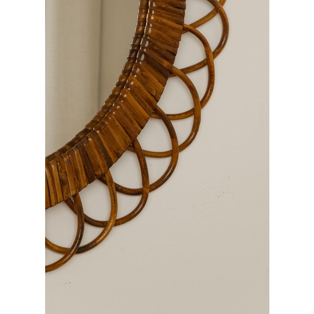Round rattan wall mirror with looped petal frame. Italian Mid Century, circa 1960s. Original mirror glass.