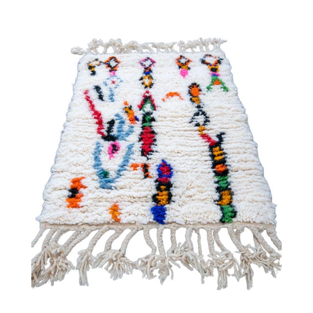 Elevate your bath space with this authentic, hand-knotted creamy Moroccan Azilal luxury rug. Showcasing a vibrant pink...