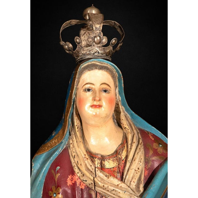 A striking Spanish Colonial polychrome carved wood sculpture depicting the Immaculate Conception, dating from the late...