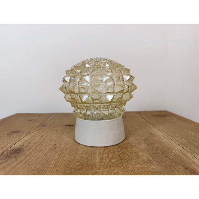 Vintage industrial ceiling or wall light made in former Czechoslivakia during the 1970s. It features a white porcelain...