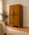 A 1930s Art Deco style wardrobe in figured walnut veneer, with two doors, decorative metal handles, shaped feet and a...