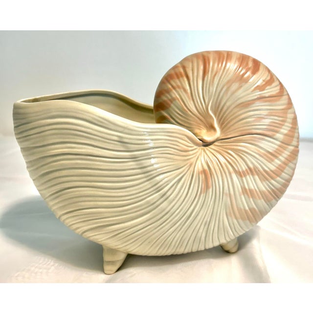 A beautifully sculptural Fitz & Floyd ceramic nautilus shell planter, showcasing the organic form and refined coastal...
