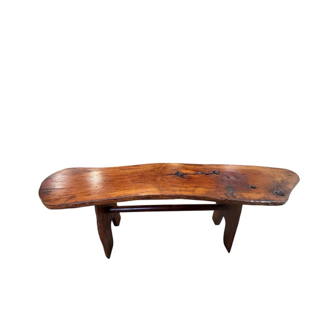 A beautifully handcrafted live-edge bench featuring a solid hardwood slab seat with natural contours, knots, and rich...