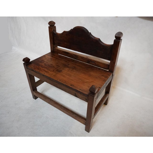 Walnut one-seater bench. Simple, but not lacking personality. The bench has four chunky faceted finials that are balanced...