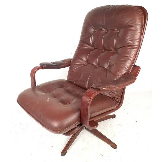 This gorgeous mid-century burgundy vinyl lounge chair and ottoman features tufted cushions, rosewood armrests, 16" seat...