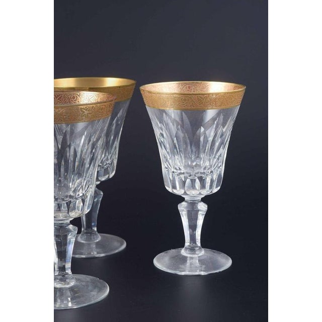Five crystal glasses with gilt rim, mid-20th century. Faceted cut crystal glasses on baluster foot, finished with a broad...