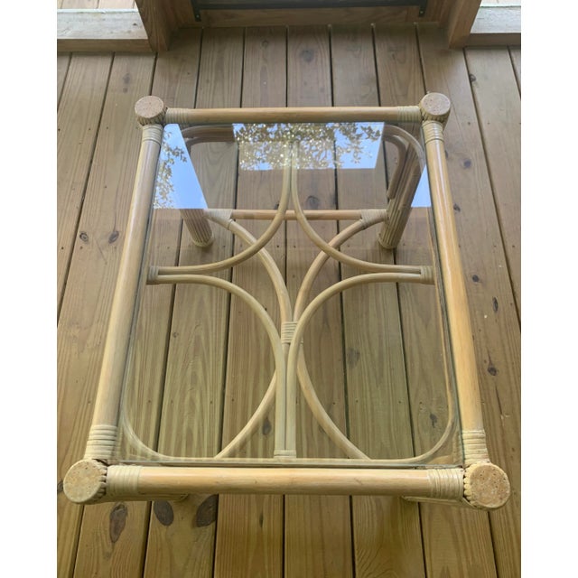 Offering a vintage rattan table with an interesting design and beachy white-washed finish and custom glass top.