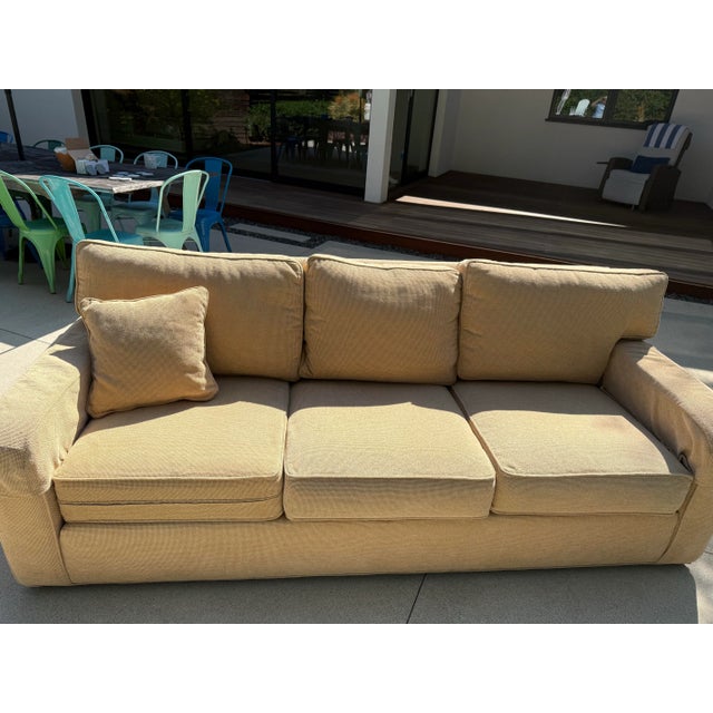 From the reputable Ethan Allen brand, this sofa and ottoman feature slender, tailored track arms and loose, welted...