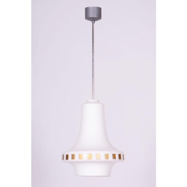 This chandelier is an excellent representative of 1960s Czechoslovak design, following the Mid-Century Modern aesthetic....