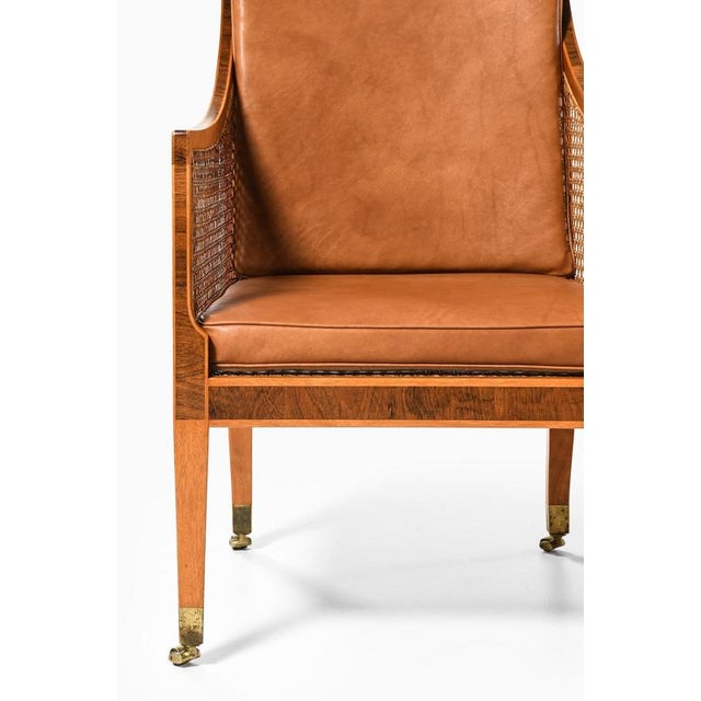 This rare pair of model 4488 bergère armchairs, designed by kaare klint in 1931 and produced by rud. Rasmussen...