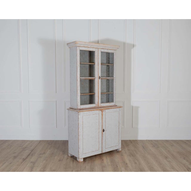 A charming Swedish bookcase from the late 19th century, newly repainted in a soft grey on the exterior with a bluish-grey...