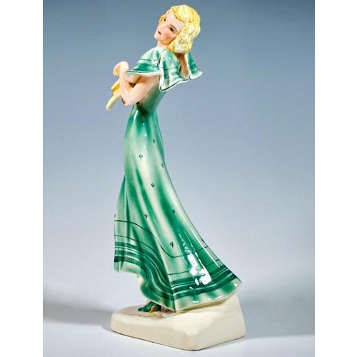 Finest viennese ceramic art from the 1930s: striding blonde girl in a green dress with softly falling shoulder pieces,...