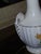 White base with painted floral bouquets and gilt gold accents. Features a gold-toned or gilt base, consistent with antique...