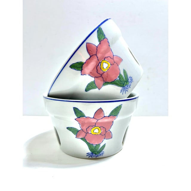 A charming pair of 1980s porcelain ventilated orchid pots featuring hand-painted floral motifs and slotted sides for...