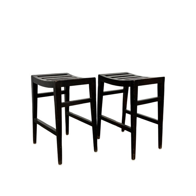 Pair of vintage counter stools by Milling Road, a division of Baker Furniture, featuring dark-finished wood construction...