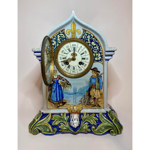 A fabulous antique Quimper Porquier Beau French faience mantel clock featuring a hand painted Breton couple overlooking...