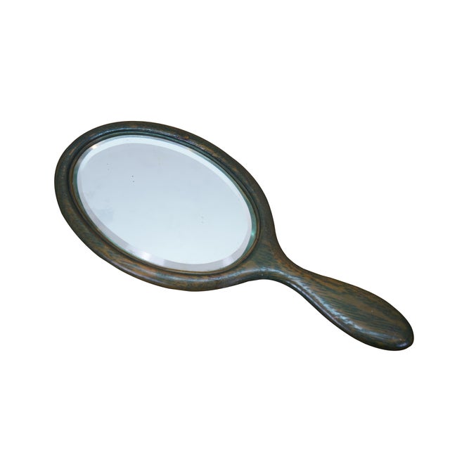 Antique Victorian vanity hand mirror featuring a beveled oval mirror and oak frame. Dimensions: 10.5" x 4.5" x 0.375"...