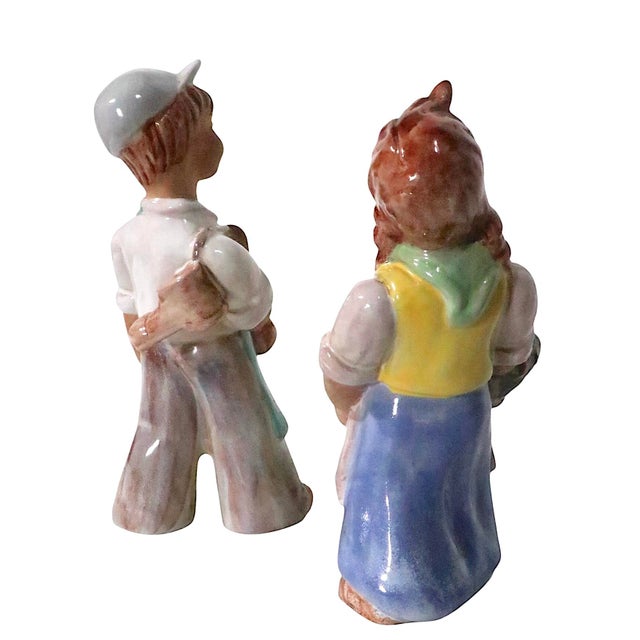 Pair of rare Art Deco period glazed terracotta figurines depicting a boy and a girl. The boy is known as The Shoemaker, or...