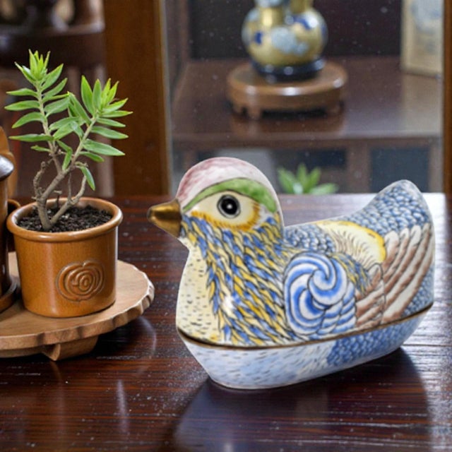 This figural trinket box is crafted in copper and finished in hand-applied cloisonné enamel, depicting a stylized bird...