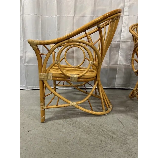 Pair of vintage 20th Century bent rattan circle sided lounge chairs with hide corner wrapping. Great pair to float in your...