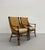 A sophisticated pair of vintage lounge chairs crafted with a curved rattan frame, tightly woven backs, and contrasting...
