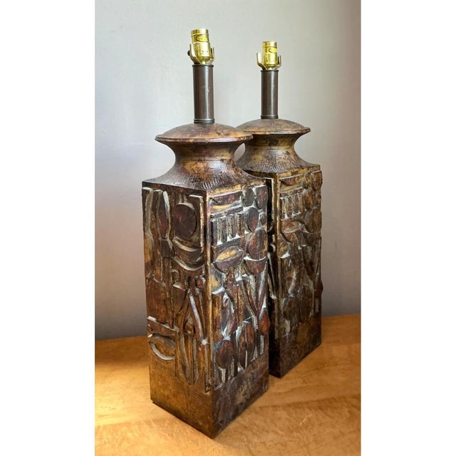 This pair of vintage ceramic lamps brings mid-century modern character to any space through abstract carved relief work....
