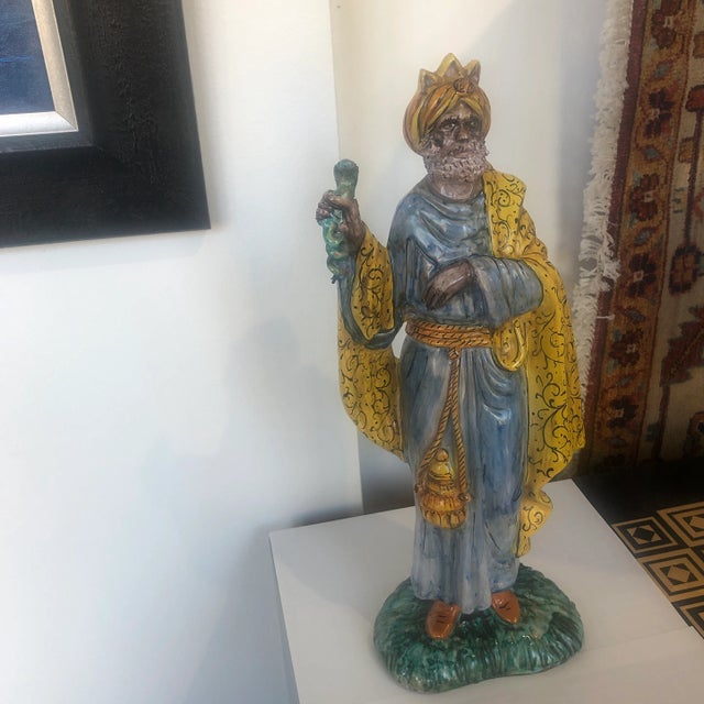 Colorfully hand painted ceramic royal figure holding a serpant in a soft patina finish. Hand made items may vary in size,...