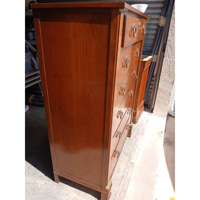 Baker Furniture American Empire-style cherry wood highboy dresser with original brass hardware and brass accents. 6 drawer...