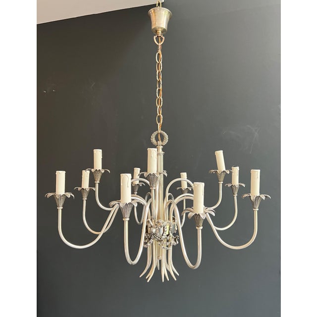 This beautiful and elegant neoclassical-style chandelier is made of silver-plated metal. It is a French work from Maison...