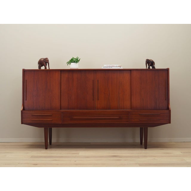 The highboard was made in the 1960s, Danish production. The structure is covered with teak veneer. The legs are made of...