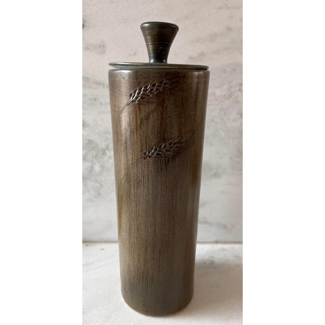 Vintage mid century ceramic tall silo jar with blue green glaze and wheat design. Unsigned, but marked with numbers on the...